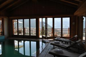 ein Zimmer mit Pool, Stuhl und Fenstern in der Unterkunft Chalet d'Adrien in Verbier