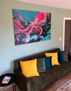 a living room with a couch with an octopus painting on the wall at Paradiesje 2 in Leer