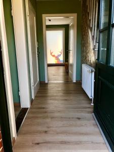 a hallway with a door with a painting on the wall at Paradiesje 2 in Leer