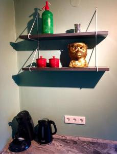 a shelf with a statue in a room with red bowls at Paradiesje 2 in Leer