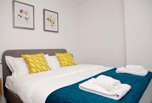 1 dormitorio con 1 cama con toallas en Soho Chambers by Indigo Flats, en Londres