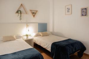 1 dormitorio con 2 camas y mesa con lámpara en Apartamentos FV Flats Valencia - Mestalla 5, en Valencia