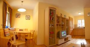 a kitchen and dining room with a table and a television at Appartement Schneeglöckchen in Bad Gastein