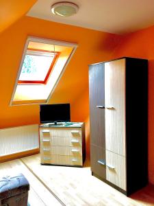 um quarto com uma clarabóia, uma cómoda e uma janela em Barbara Apartmanház em Kehidakustány