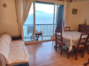 a living room with a table and a view of the ocean at Joli appartement face à la mer- Grisgione in San-Martino-di-Lota