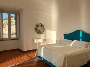 a bedroom with a bed and a mirror and a window at Dipintodiblù in Meta