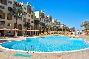 a large swimming pool in front of a building at Adel Apartments at alkarma resorts& aquapark in Hurghada