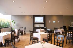 a dining room with tables and chairs and a screen at Hotel Brasilia in Mexico City