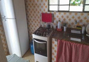 una pequeña cocina con fogones y fregadero en Hostel 3.5 en Ubatuba
