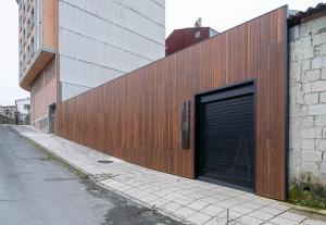 a large garage door on a building next to a street at Dpaso hostel in Chantada