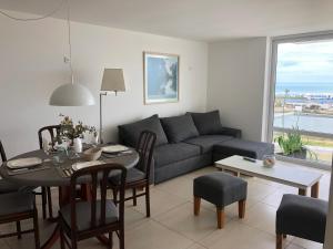 a living room with a couch and a table at Susurros del Mar, Amplio semi-piso frente al mar in Mar del Plata