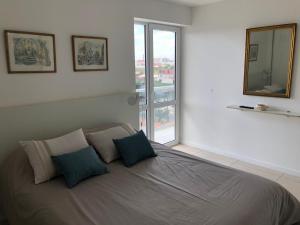 a bed in a room with a mirror and a window at Susurros del Mar, Amplio semi-piso frente al mar in Mar del Plata