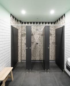 uma casa de banho com portas pretas e um banco de madeira em Dpaso hostel em Chantada