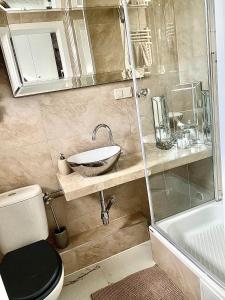 a bathroom with a sink and a toilet and a shower at Glamour Apartment przy plaży, z parkingiem prywatnym in Sopot