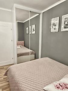 a bedroom with a bed and a mirror at Glamour Apartment przy plaży, z parkingiem prywatnym in Sopot