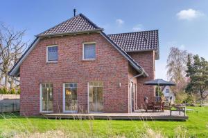 a red brick house with a table and an umbrella at Ferienhaus 3f in Prerow
