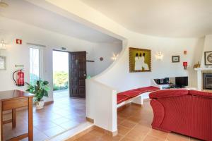 a living room with a red couch and a fireplace at Villa Oceanis in Luz