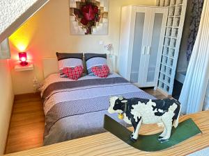 Un dormitorio con una cama con una vaca encima. en Gite St Léon à Eguisheim, en Eguisheim