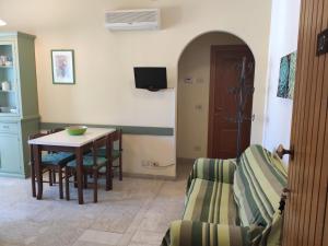 a living room with a table and chairs and a door at Appartamenti Bemar in Diano Marina