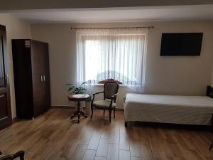 a bedroom with a bed and a table and a window at Apartamenty Avanti-Stare Miasto Zamość in Zamość