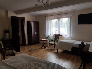 ザモシチにあるApartamenty Avanti-Stare Miasto Zamośćのベッドルーム1室(ベッド2台、テーブル、窓付)