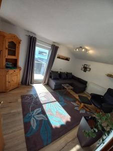 salon z kanapą i stołem w obiekcie Appartement Müllner w mieście Kirchdorf in Tirol
