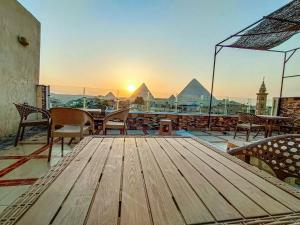 a patio area with chairs, tables, and benches at Happy Days Pyramids View in Cairo