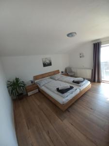 sypialnia z dużym łóżkiem i drewnianą podłogą w obiekcie Appartement Müllner w mieście Kirchdorf in Tirol