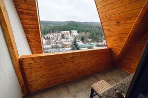 ventana en una habitación con vistas a la montaña en Popasul Domnesc- Resort& Spa- Voronet Vue en Voronet