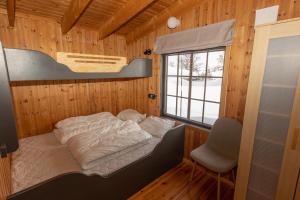 a bedroom with a bed in a wooden room at Fidjeland Fjellgrend in Fidjeland