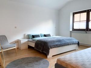 a bedroom with a bed and a chair and a window at Ferienwohnung Burgpanorama in Dahn
