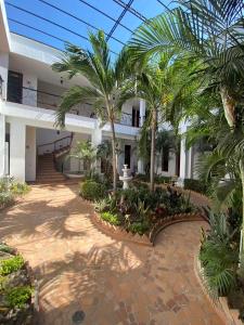 un patio con palmeras frente a un edificio en Hotel Casa Bethel, en Santa Marta