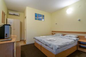 małą sypialnię z łóżkiem i telewizorem w obiekcie Atlantic Complex Ravda w Rawdzie