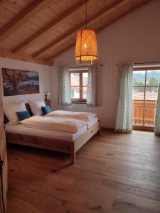a bedroom with a large bed and a large window at Landhaus Hutter in Bad Heilbrunn