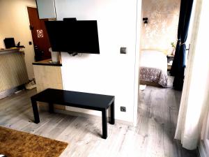 a living room with a table and a flat screen tv at 36 Dajot Boutique Apartment - 70 in Melun