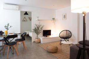 a living room with a table and chairs and a television at Apartamentos FV Flats Valencia - Mestalla 7 in Valencia