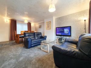 Il comprend un salon avec des canapés et une télévision à écran plat. dans l'établissement 3 bedroom house Amazon M90 Dunfermline Edinburgh, à Fife