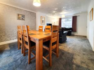 a dining room with a wooden table and chairs at 3 bedroom house Amazon M90 Dunfermline Edinburgh in Fife
