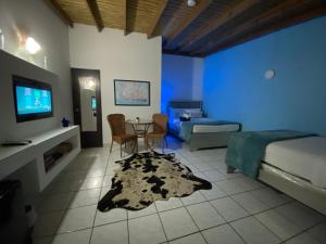 um quarto com uma cama, uma televisão e uma mesa em Luichy's Seaside Hotel at Playa El Combate em El Combate