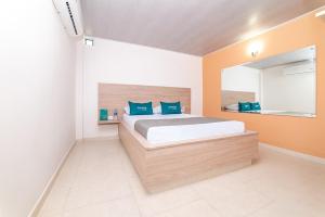 um quarto com uma cama grande e almofadas azuis em Ayenda Hospedaje WIV em Cúcuta