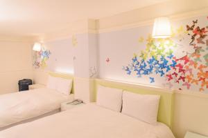 a bedroom with two beds and a painting on the wall at Kiwi Express Hotel - Zhong Zheng Branch in Taichung +32 photos