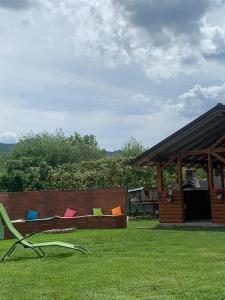 einen Garten mit einer Bank mit Stühlen im Gras in der Unterkunft Cazare ieftina in Piatra Neamţ