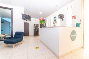 a waiting room with a blue chair and a counter at Ayenda Hospedaje WIV in Cúcuta