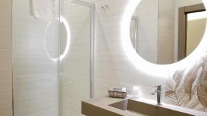 un baño con lavabo y espejo en Perla dello Ionio luxury apartments, en Torre Lapillo