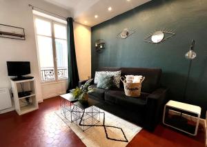 uma sala de estar com um sofá preto e uma janela em Studio vieil Antibes em Antibes