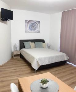 sypialnia z dużym łóżkiem i stołem z dużym sześciennym w obiekcie Jade Apartman w Hévízie