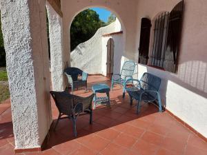 Un grupo de sillas y mesas en un patio. en Villa Secchi bifamiliare sul mare IUNP4784, en Sorso