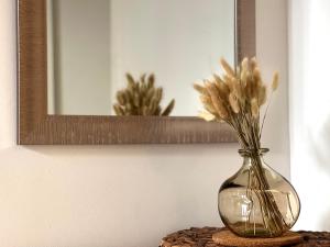 um vaso com flores sobre uma mesa em frente a um espelho em Studio vieil Antibes em Antibes