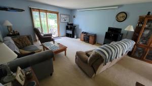 uma sala de estar com um sofá e uma mesa em Moreland Air Venture Rooms em Oshkosh