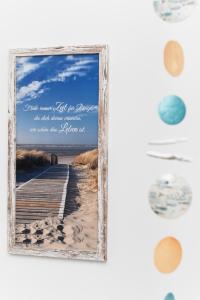 a picture frame hanging on a wall with a beach boardwalk at Ferienhaus Licht in Dornumersiel